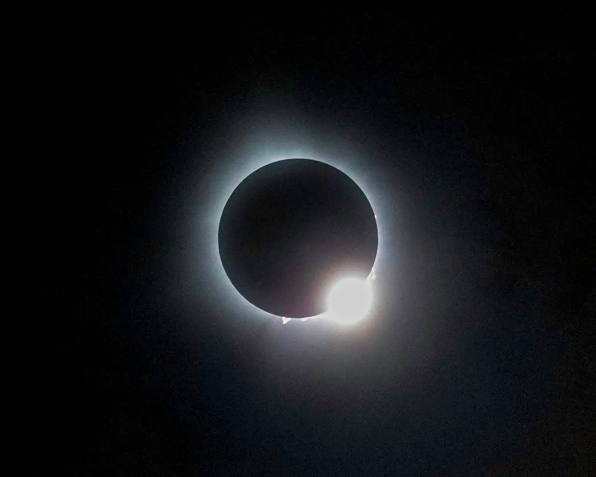 The 2024 eclipse captured during “diamond ring” effect. The diamond ring happens the moment before and after the eclipse. Also visible are several solar flares or prominences. The one on the bottom could easily contain the Earth. The white halo is the cor