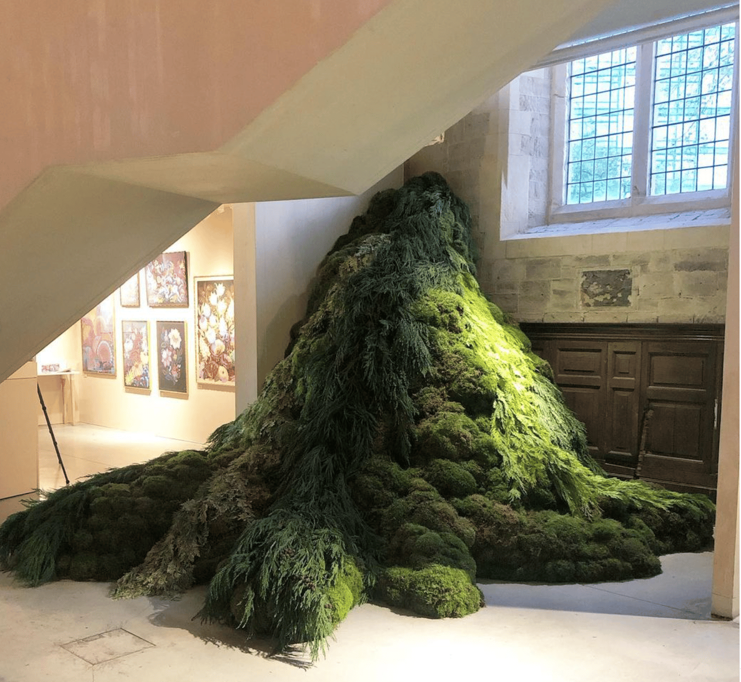 A living sculpture of evergreen boughs and mosses spilling from a wall.