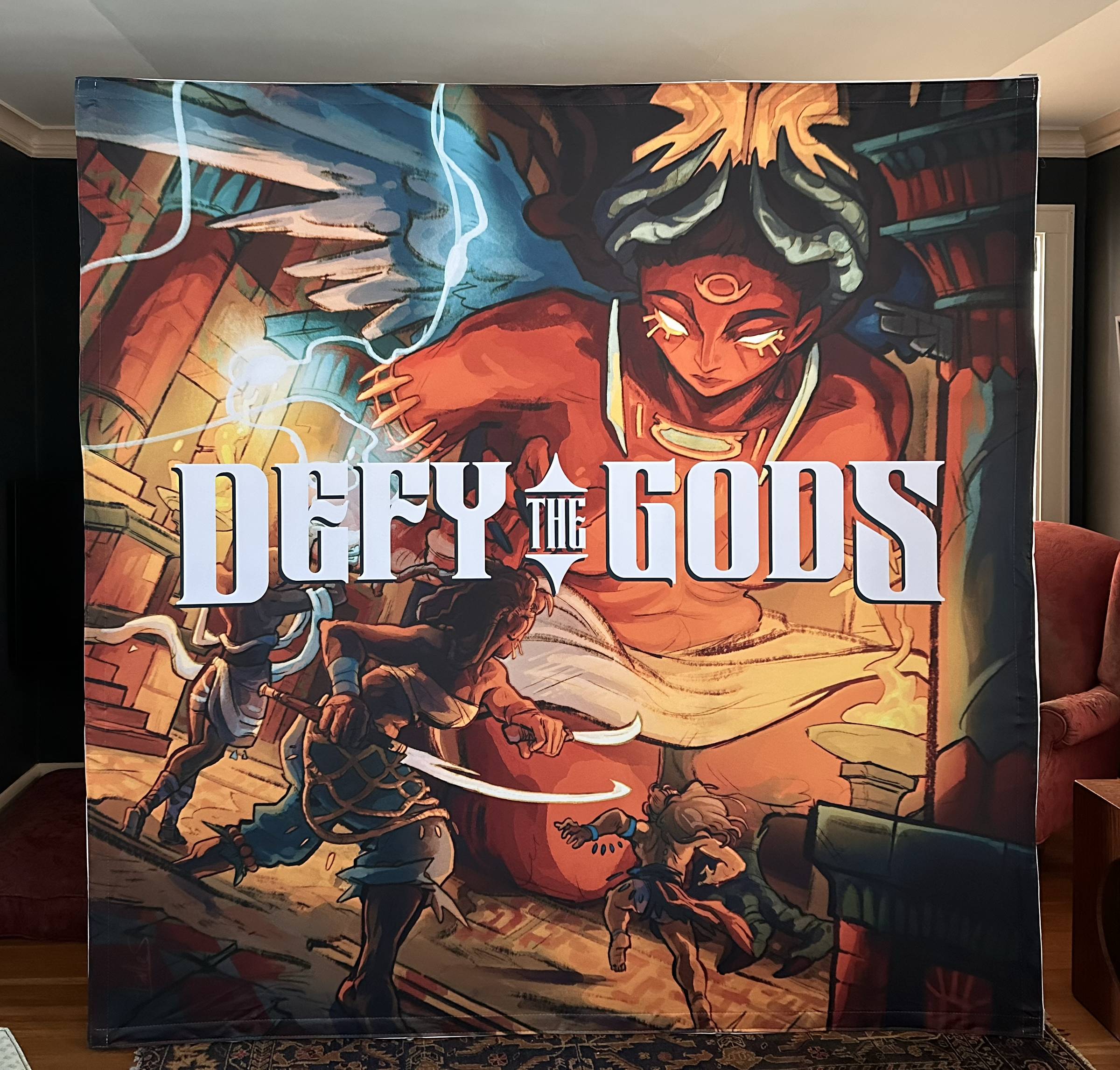 8-foot-high booth graphic of Defy the Gods promo graphic and title in my living room