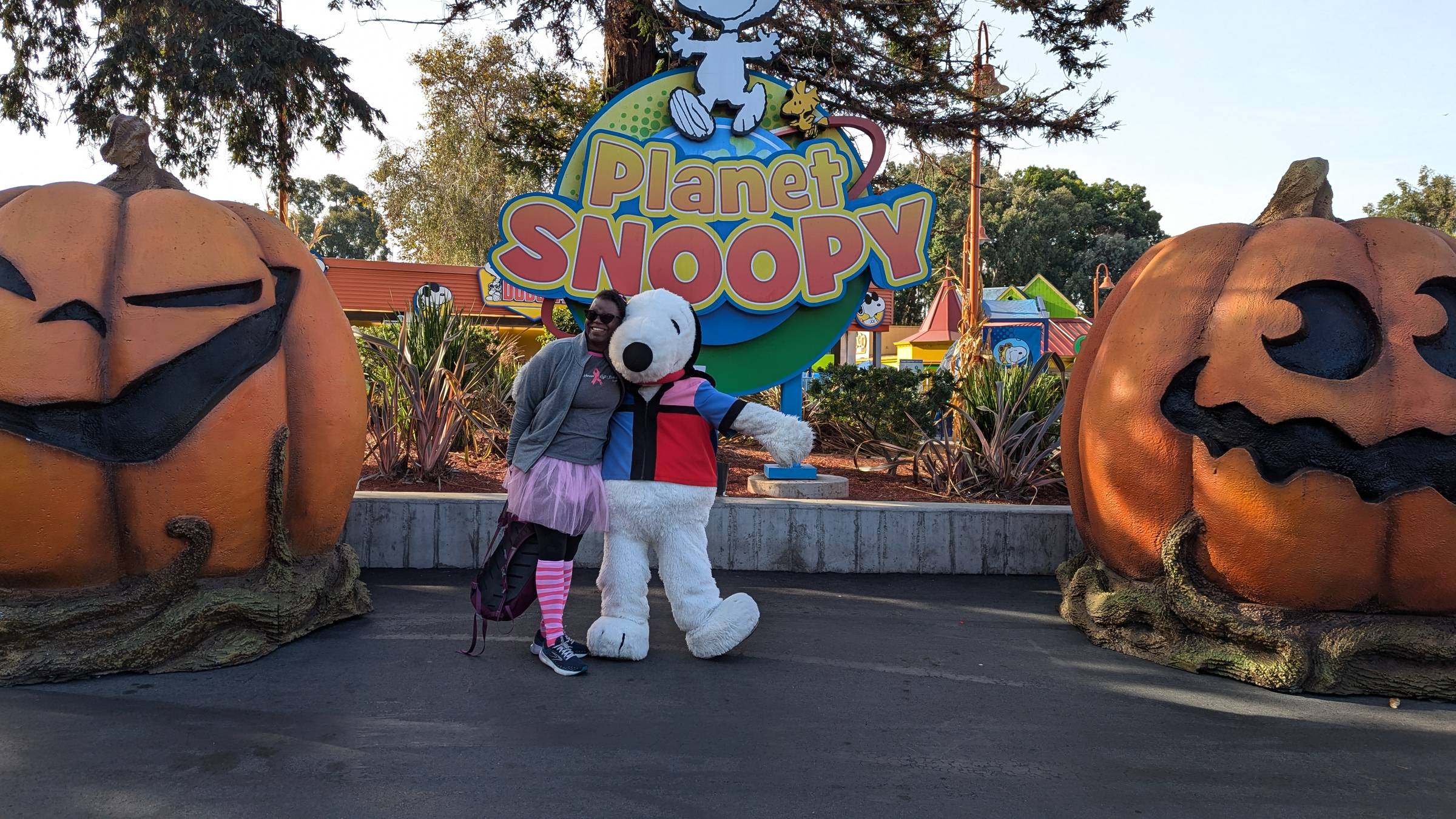 Dr. Abigail and Snoopy characer surrounded by large pumpkins.