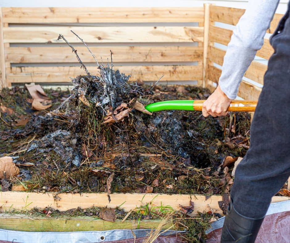 A gardener turning a winter compost pile.
