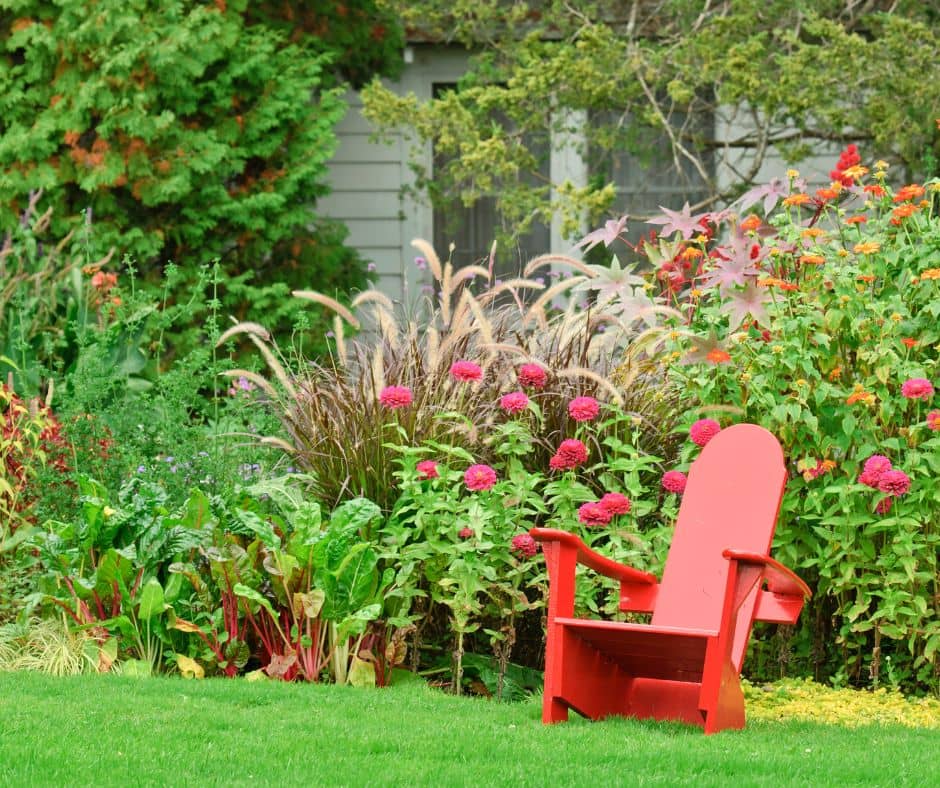 A red chair in a peaceful garden.