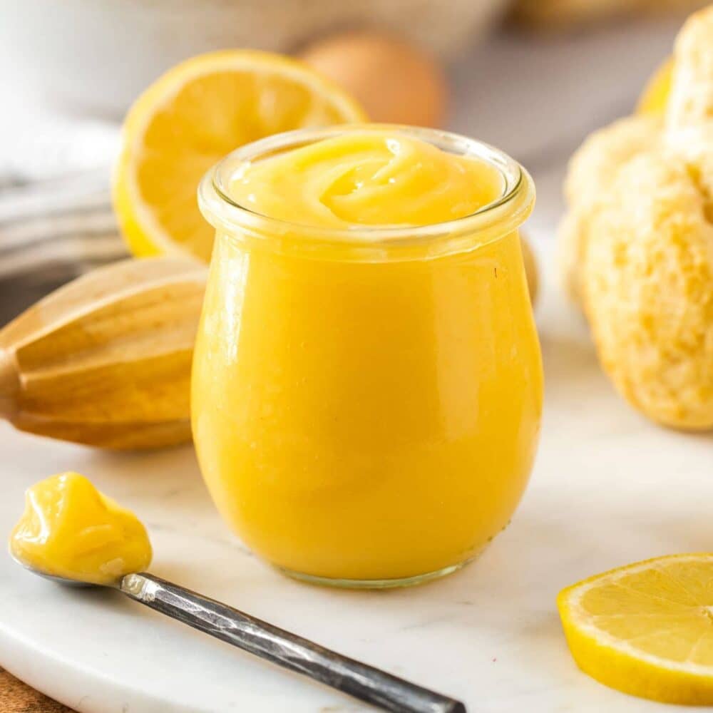 A small glass pot filled with lemon curd.