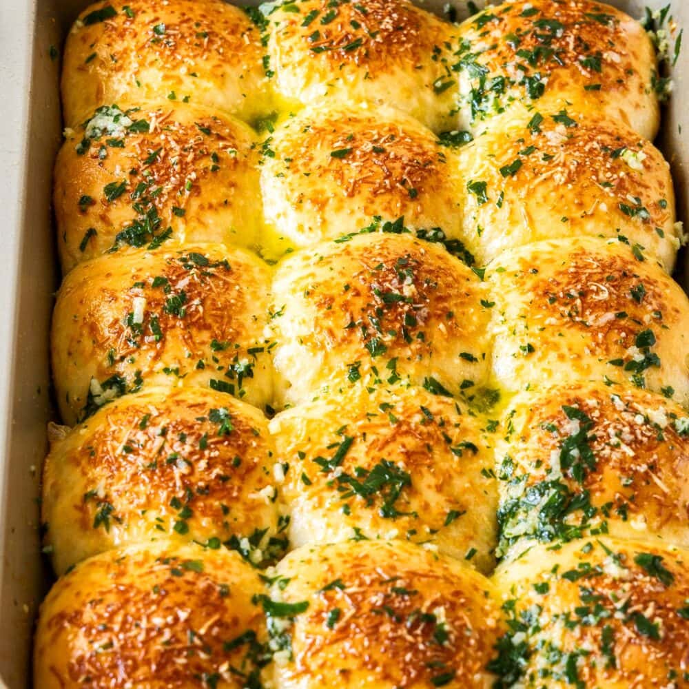 A batch of 12 garlic dinner rolls in a baking tray.