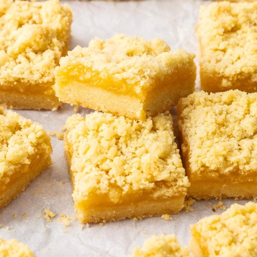 Two lemon curd bars, one resting on the edge of another.