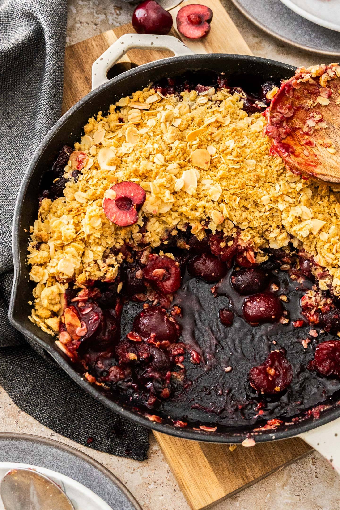 Top down view of a cherry crumble showing the gooey fruit underneath.