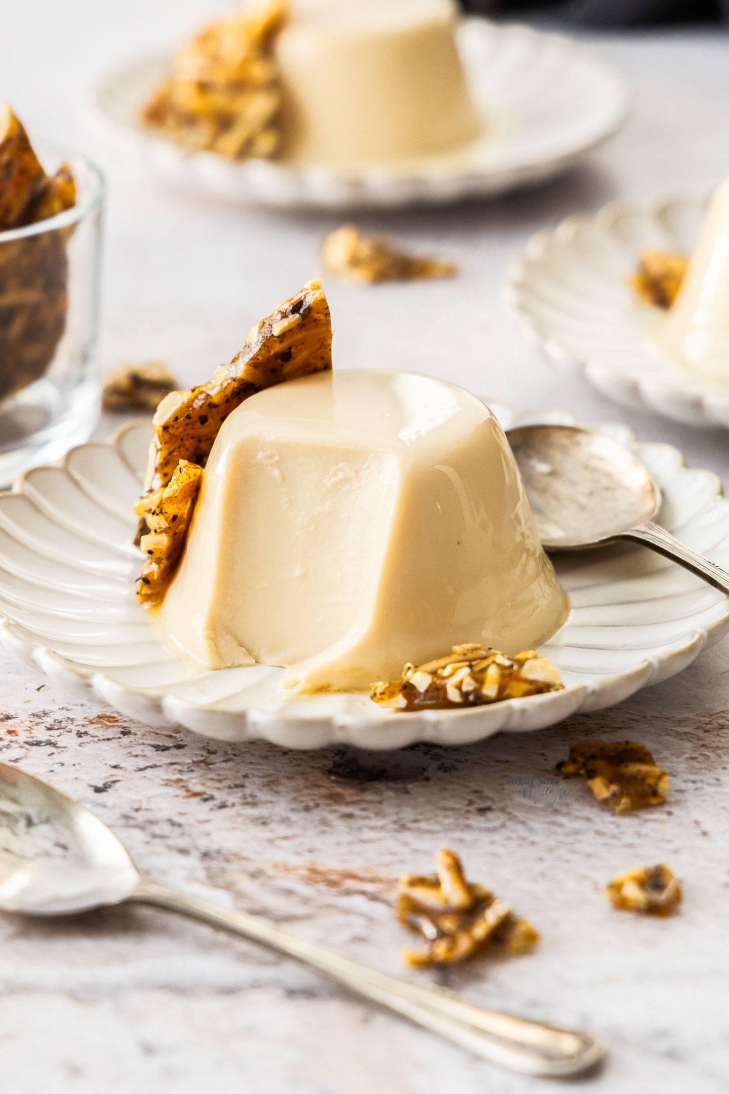 A Baileys panna cotta on a dessert plate with a scoop taken out.