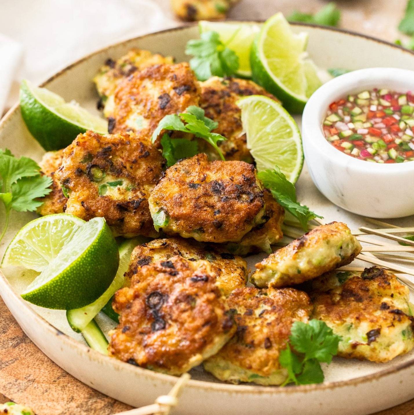 Closeup of a pile of Thai fish cakes in a bowl.