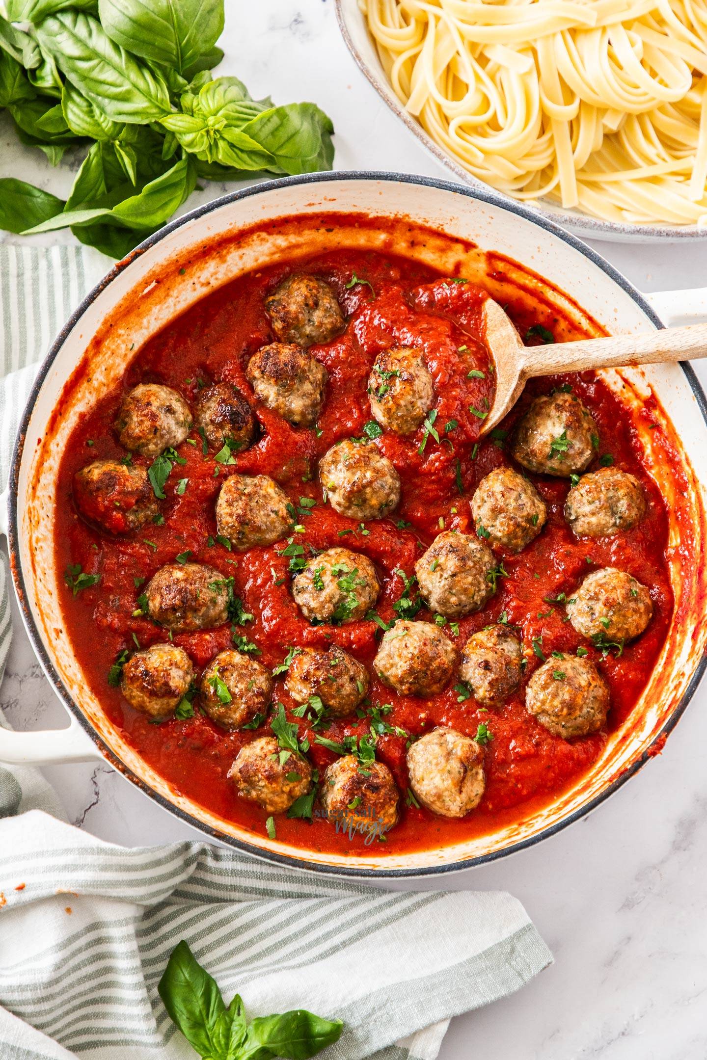 Top down view of a pan full of tomato pasta sauce with meatballs.