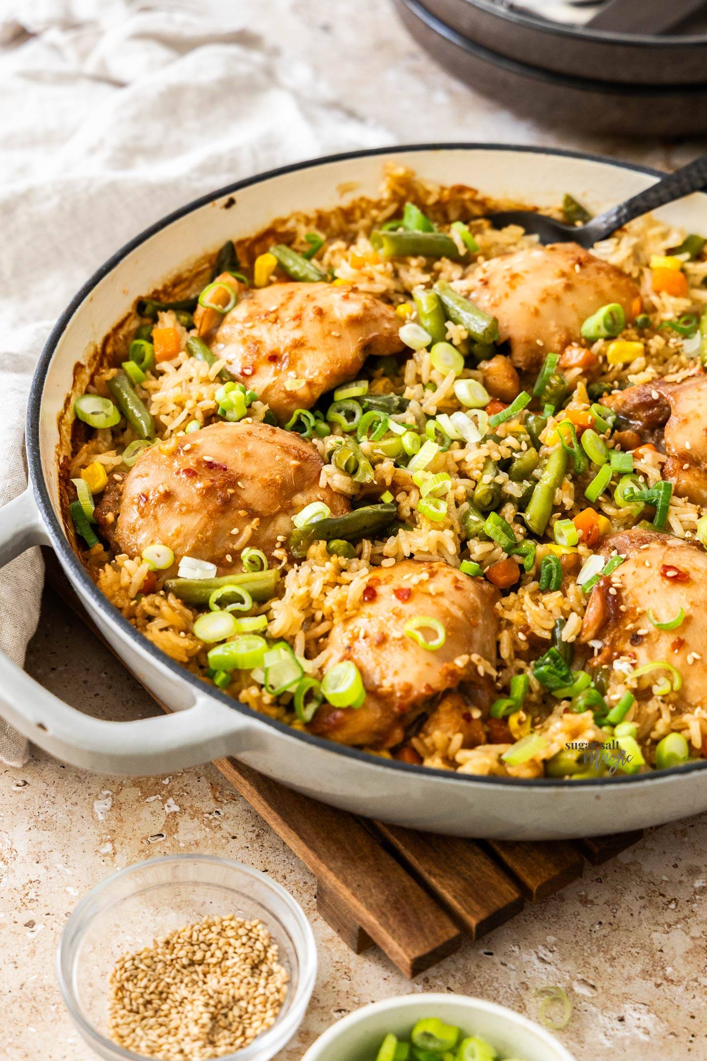 An enameled braiser pan filled with baked chicken and rice.