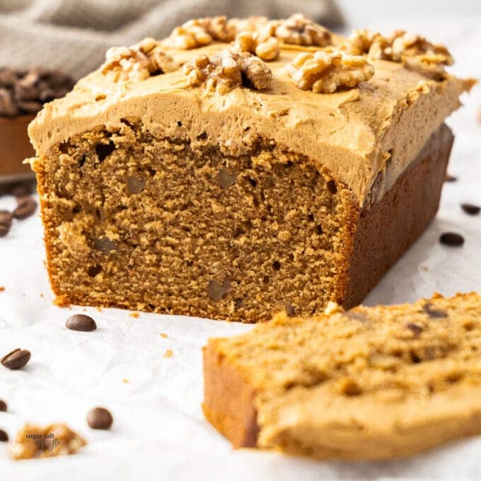 A coffee walnut loaf cake with a slice cut away.
