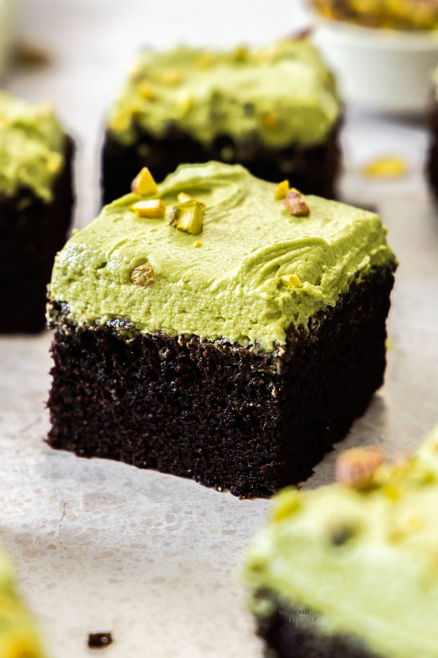 Closeup of a square of pistachio chocolate snack cake.