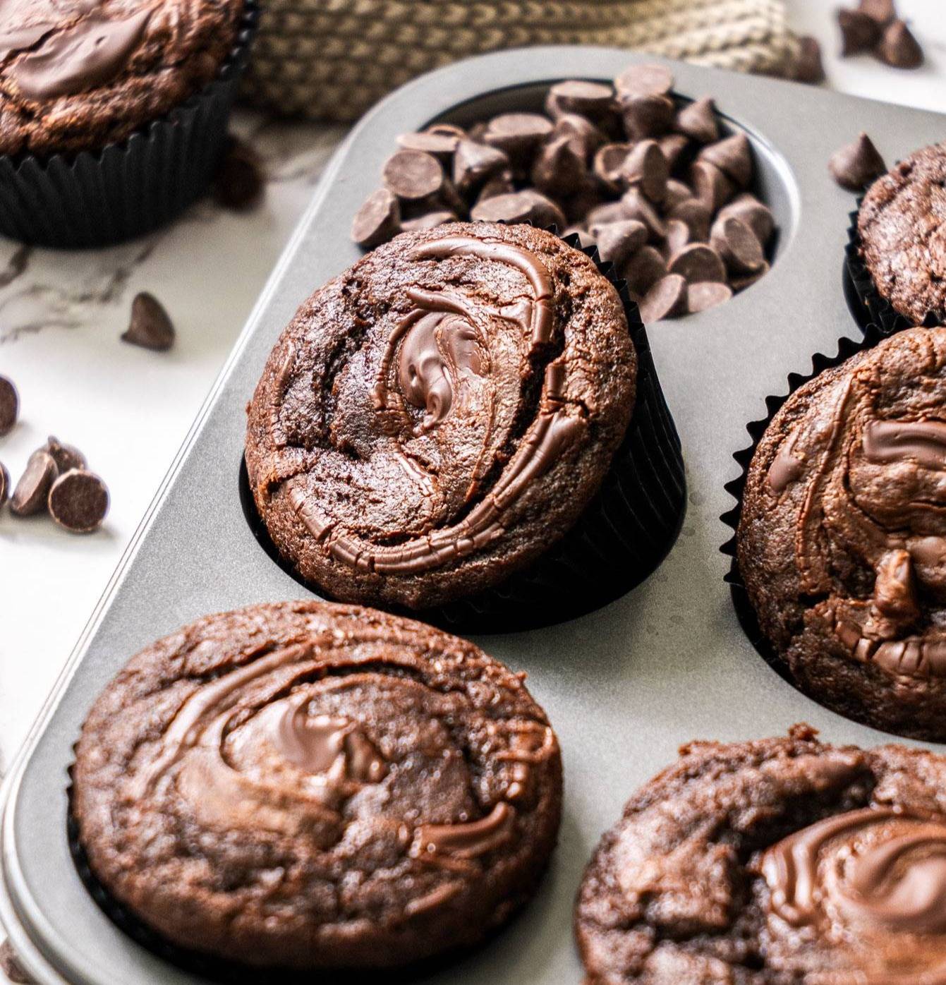 A chocolate muffin in a pan.