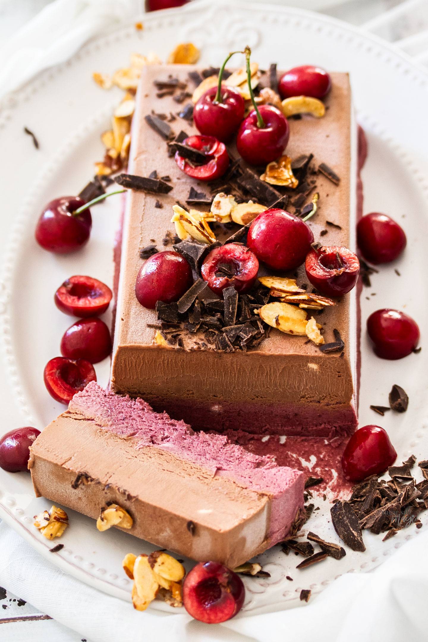 A frozen parfait on a serving platter with one slice cut away.