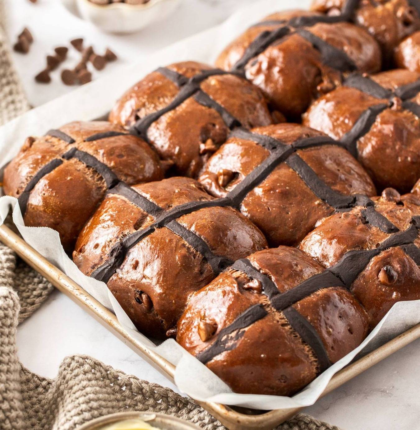 8 chocolate hot cross buns in a baking pan.