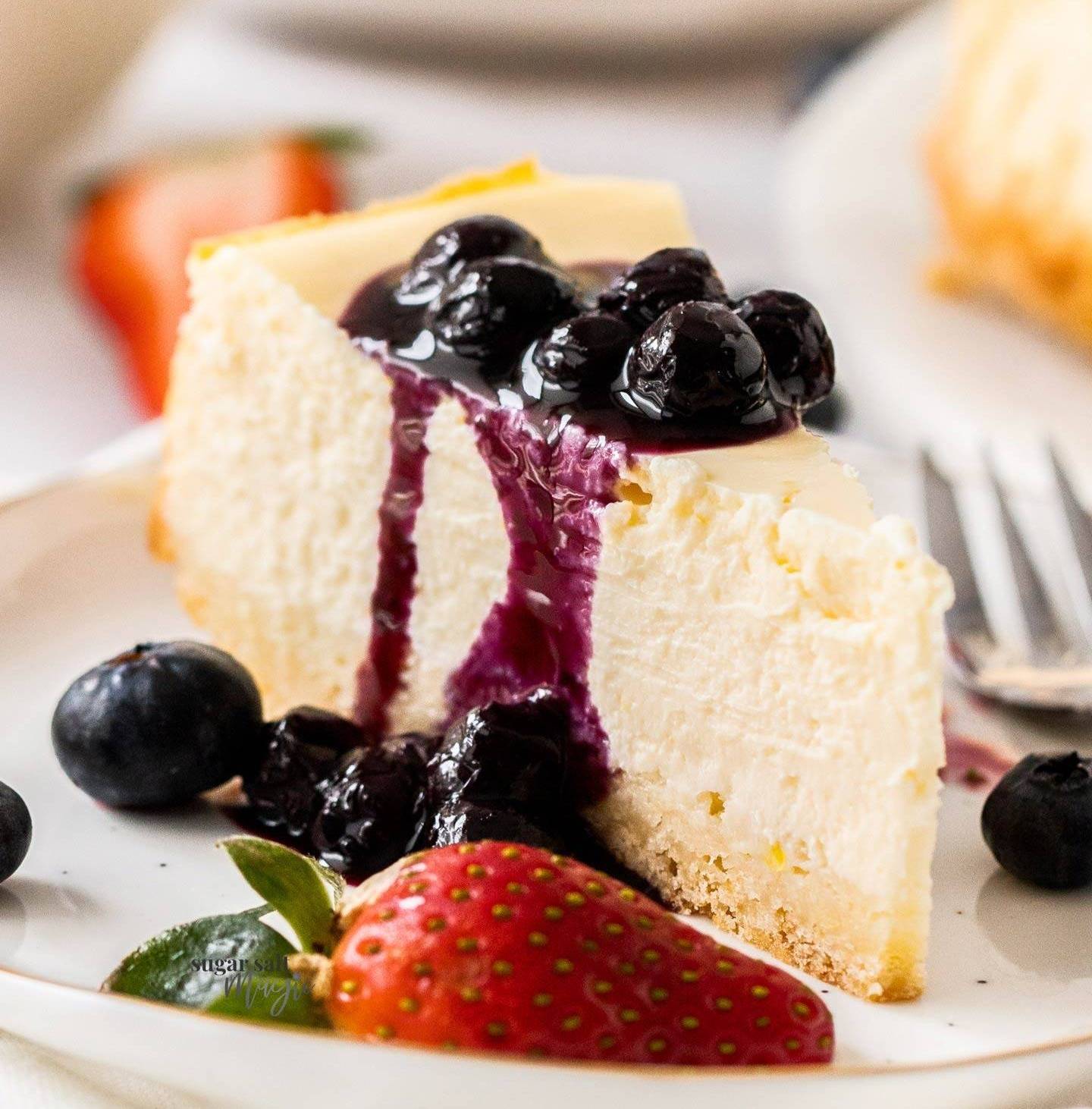 A slice of cheesecake on a plate topped with blueberry sauce.