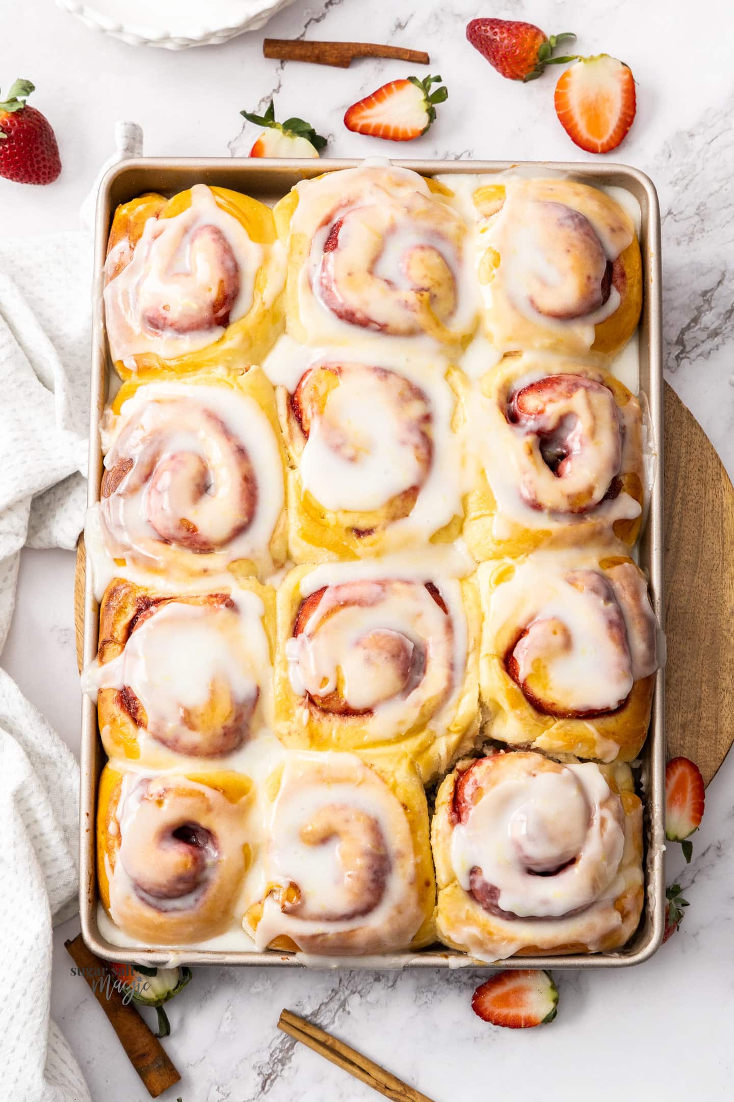 Top down view of a batch of 12 strawberry cinnamon rolls.