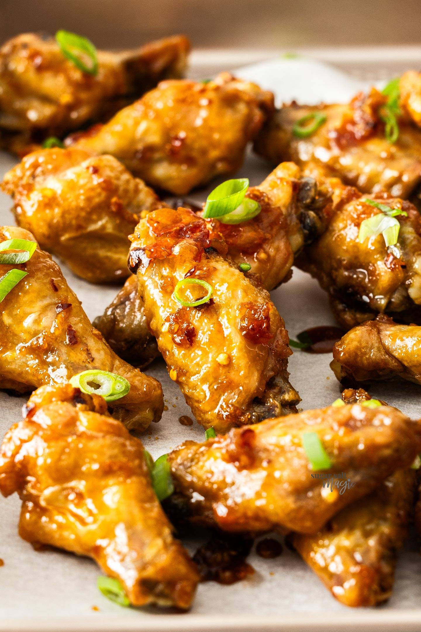 A pile of honey garlic chicken wings on a tray.