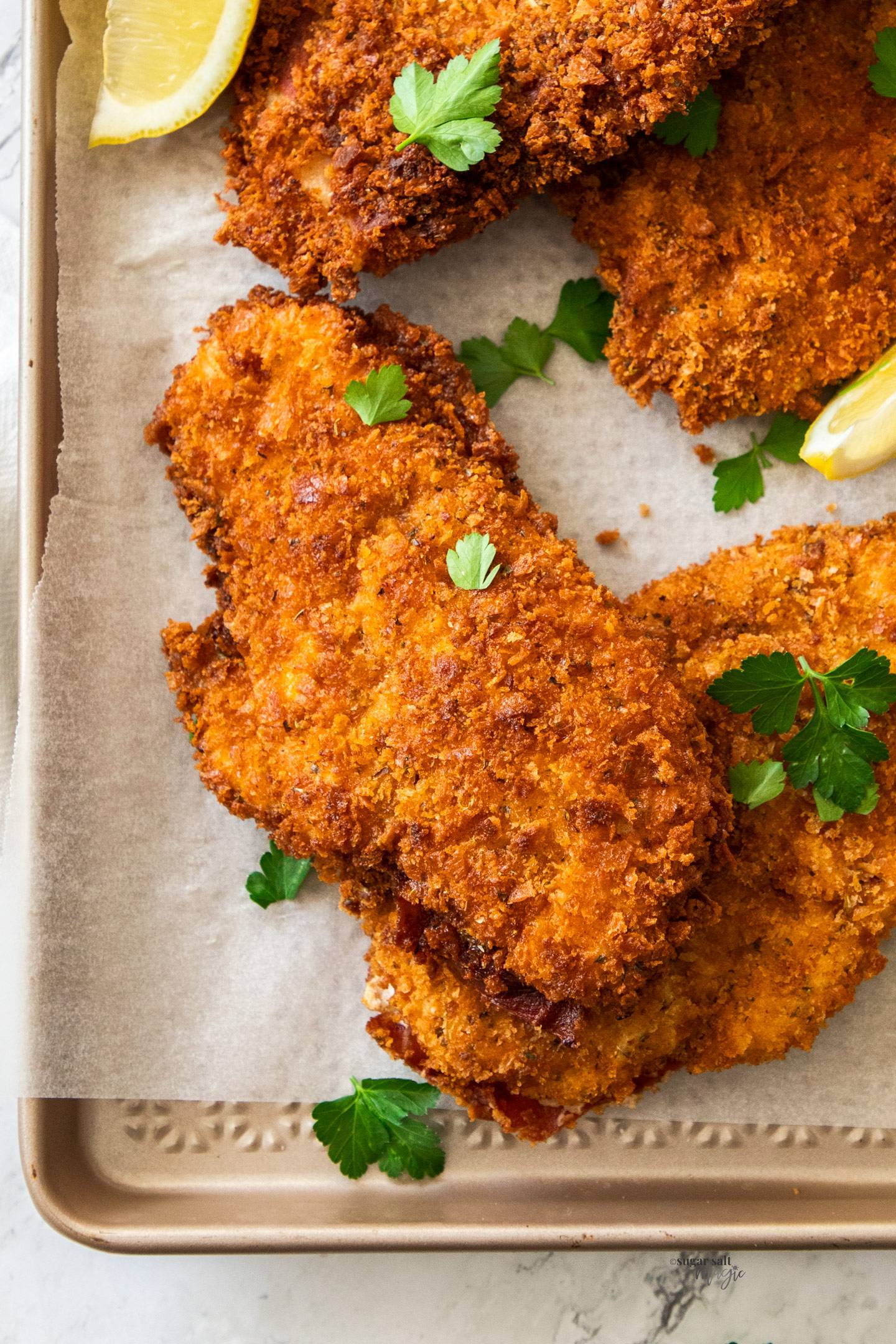 Top down view of chicken schnitzels on a baking tray.