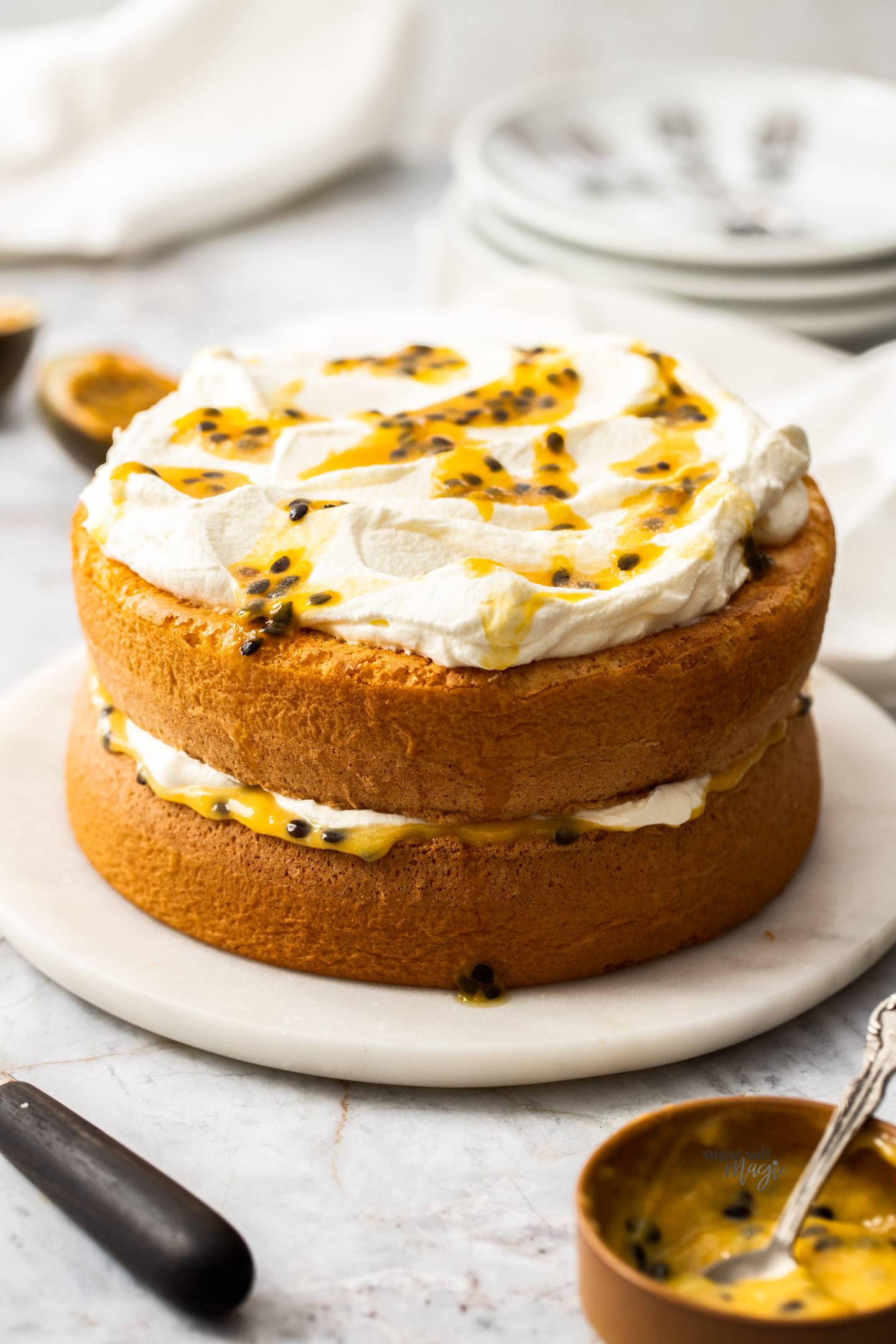 A dual layer cake topped with cream and passionfruit pulp.