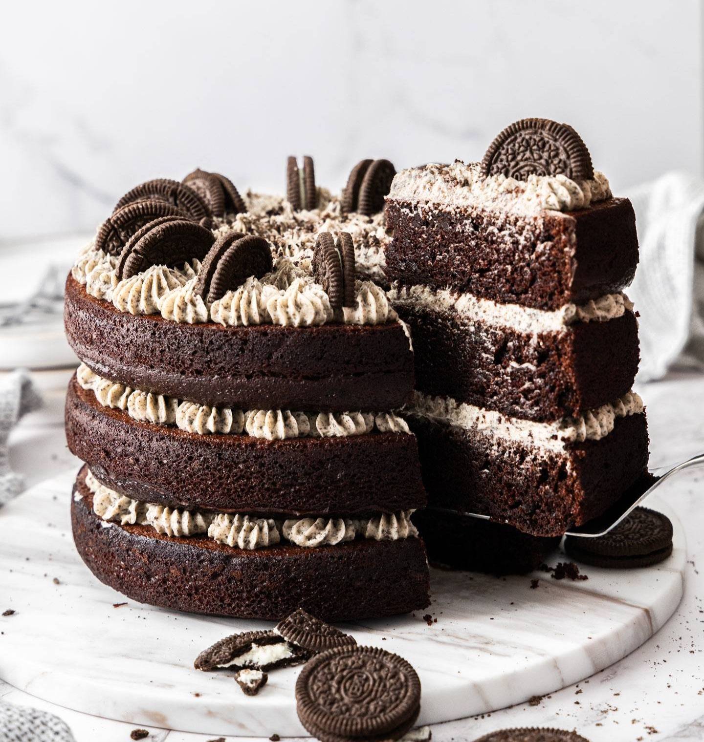 A triple layer chocolate cake topped with Oreos.