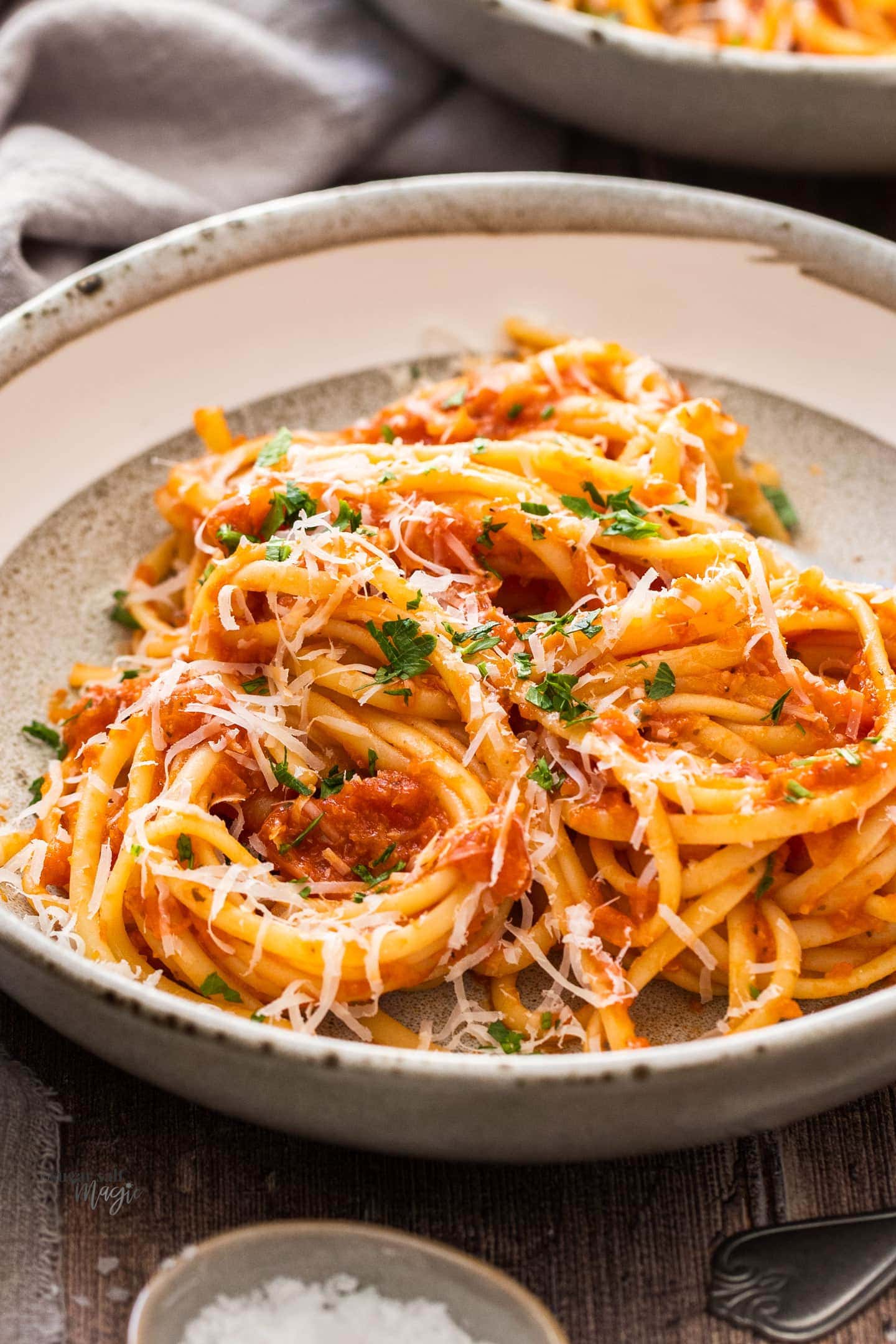 A bowl filled with linguine coated in napolitana sauce.