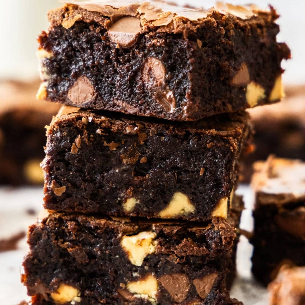 A stack of 3 chocolate brownies with chocolate chips.