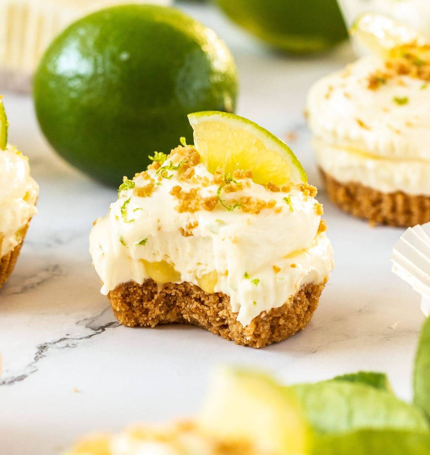 A small lime cheesecake with a bite taken out of it.