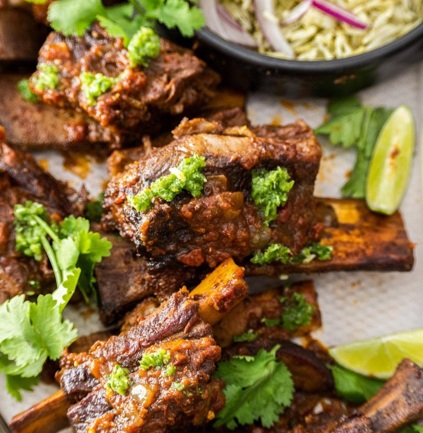 Closeup of Mexican short ribs topped with chimichurri.