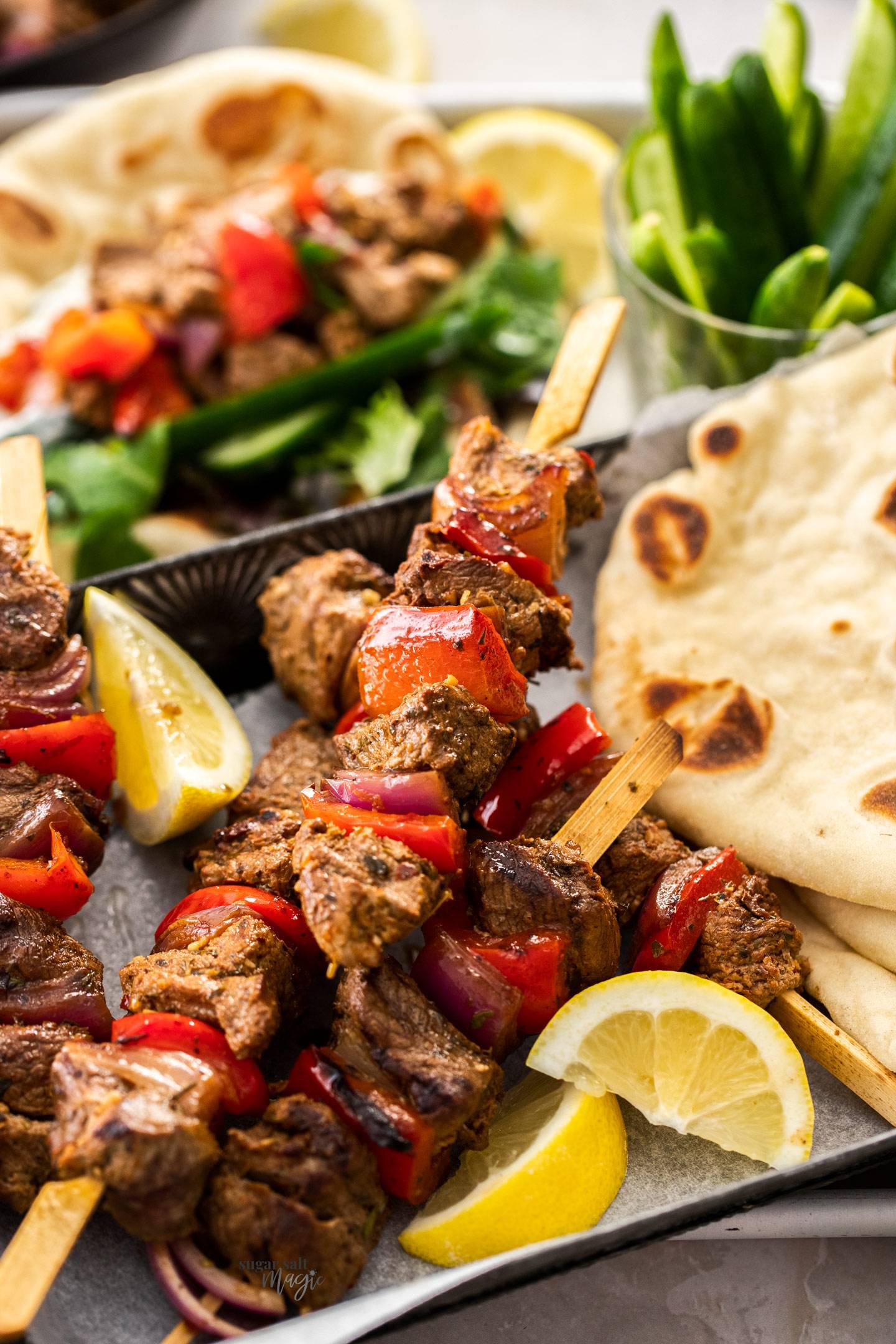 Closeup of lamb kebabs on a metal tray.