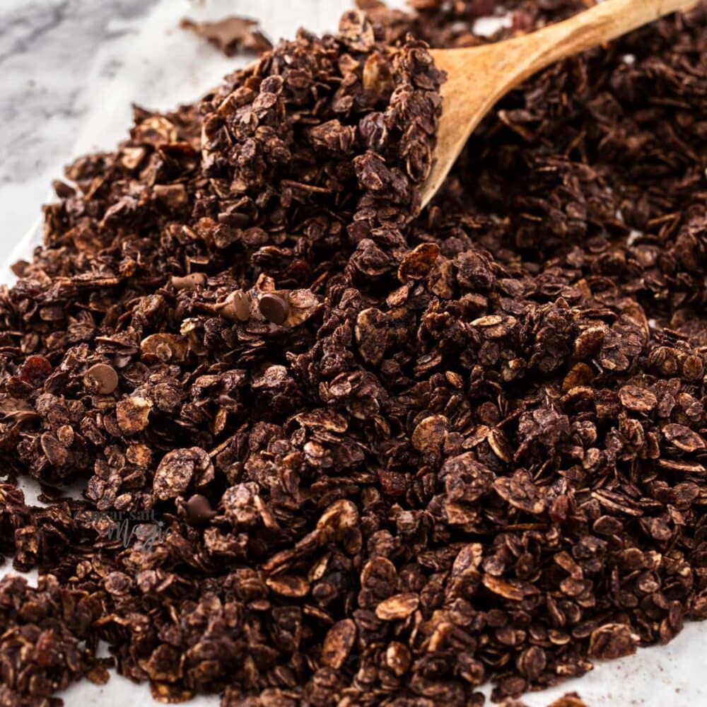 A pile of chocolate granola on a marble surface.