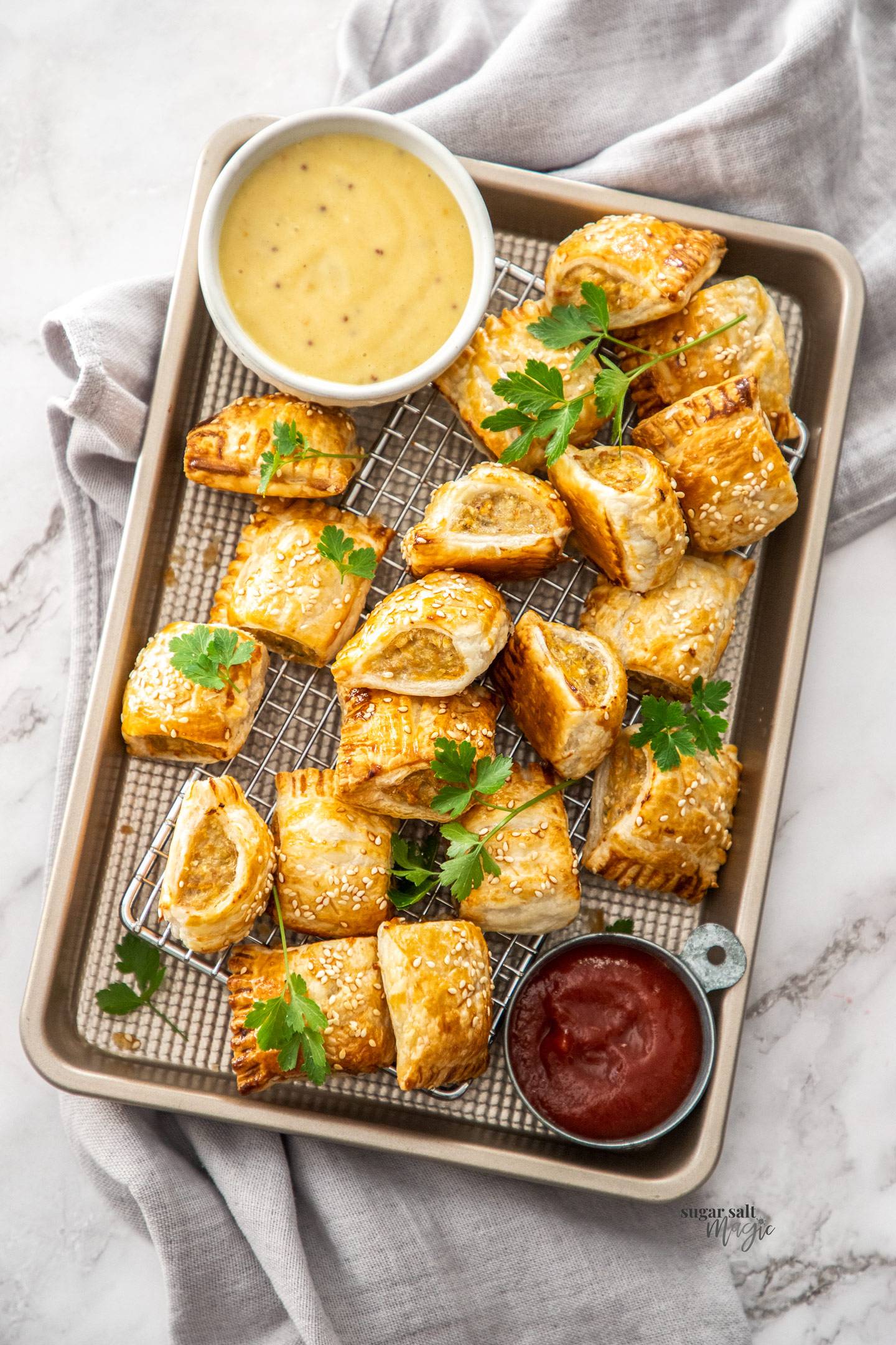 Top down view of a tray filled with chicken sausage rolls.
