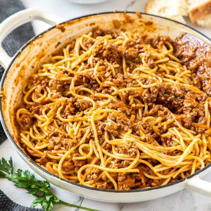 A pan filled with spaghetti in a bolognese sauce.