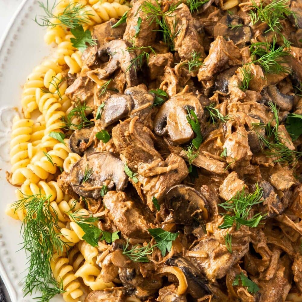 Top down view of beef stroganoff on pasta.