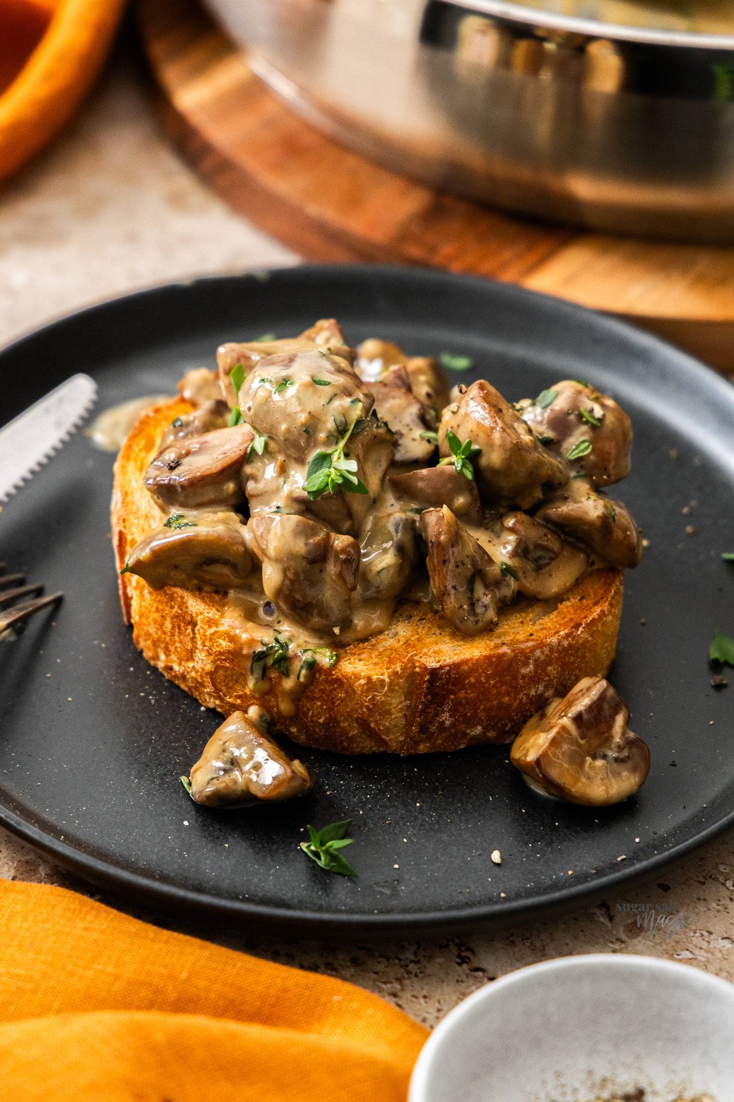A thick slice of toast topped with creamy mushrooms.