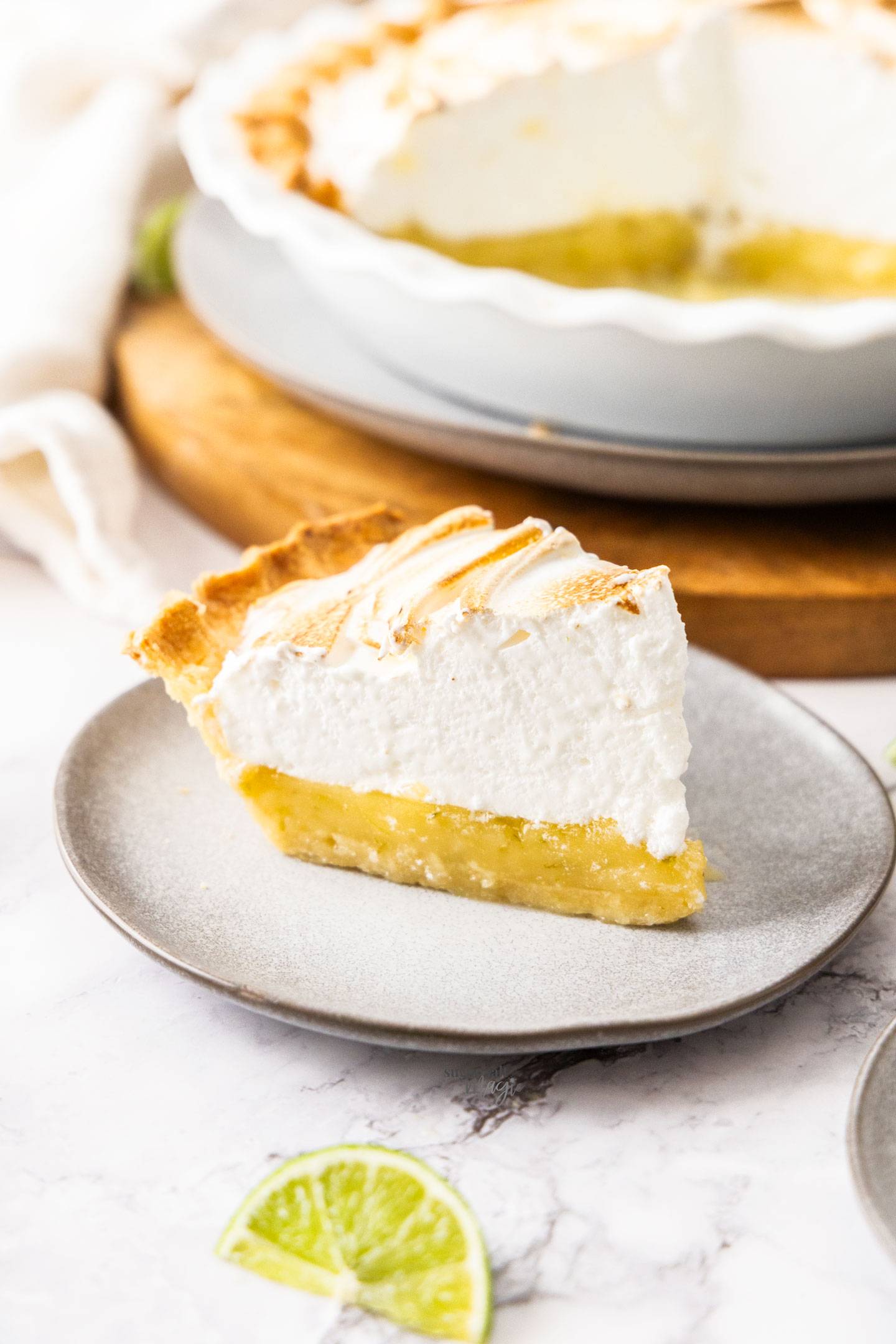A slice of lime meringue pie on a dessert plate.