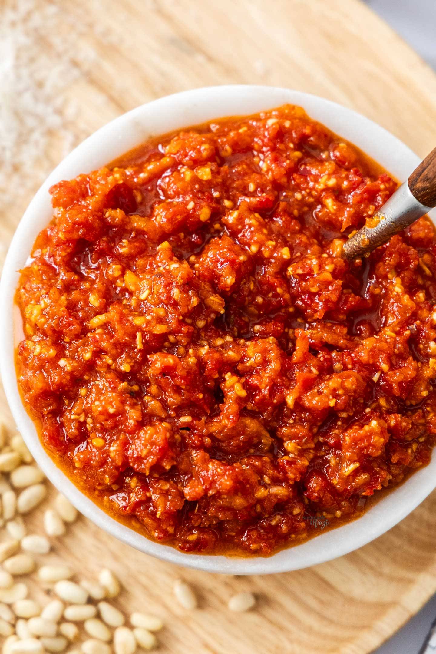 Top down view of a marble bowl filled with sun dried tomato pesto.