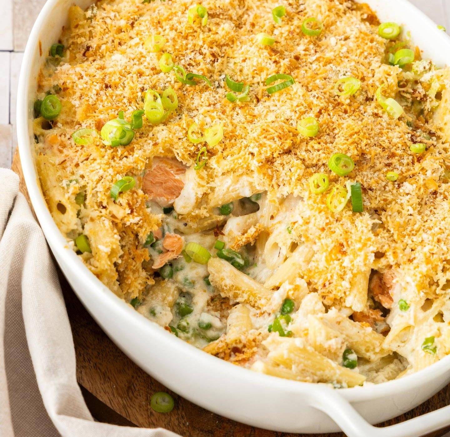 A baking dish filled with salmon and pasta and topped with breadcrumbs.