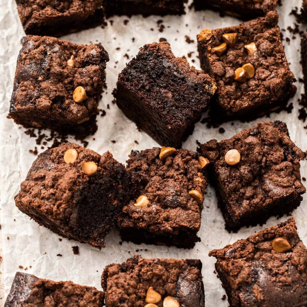 Squares of chocolate crumb cake on a sheet of baking paper.