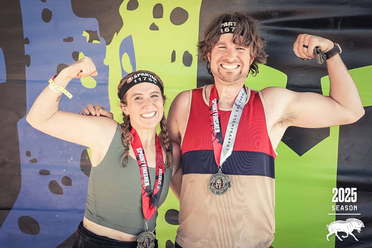 Hayley and her brother holding up strong arms and smiling at the camera, post-race
