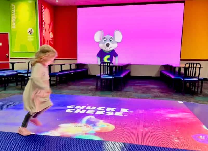 young girl running around at chuck e cheese