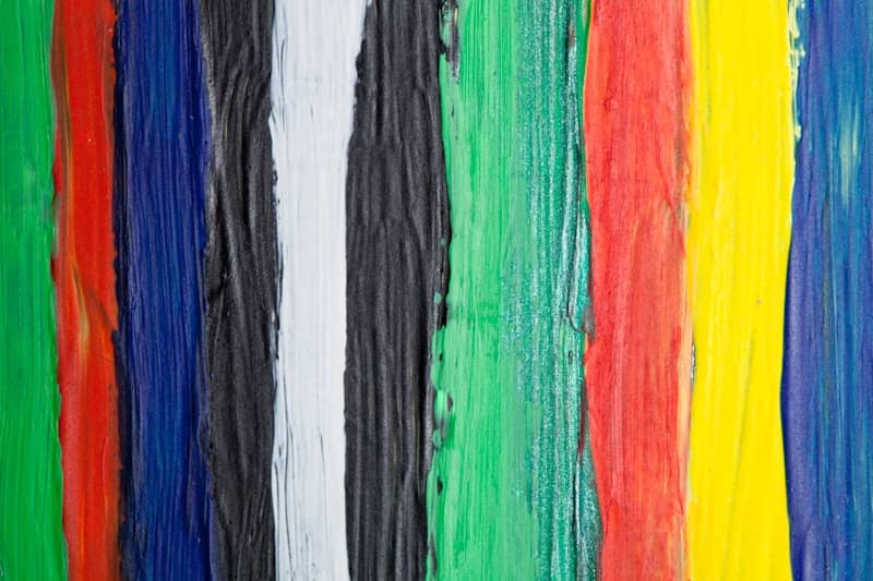 A group of multicolored strips of paint on a wall