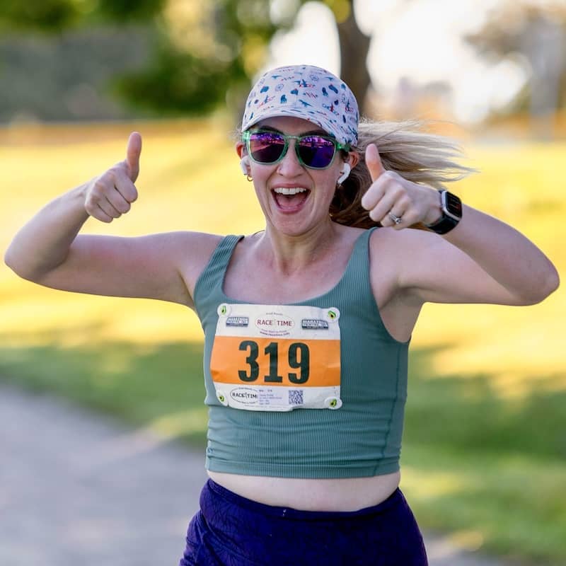 Hayley running her half marathon with two thumbs up