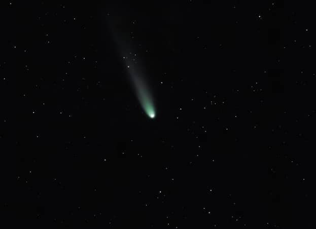 A bright comet with a long tail in starry sky