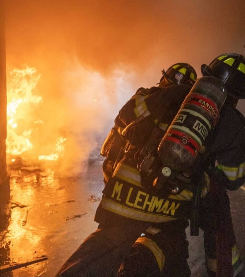 Firefighters battling a large blaze with intense flames.