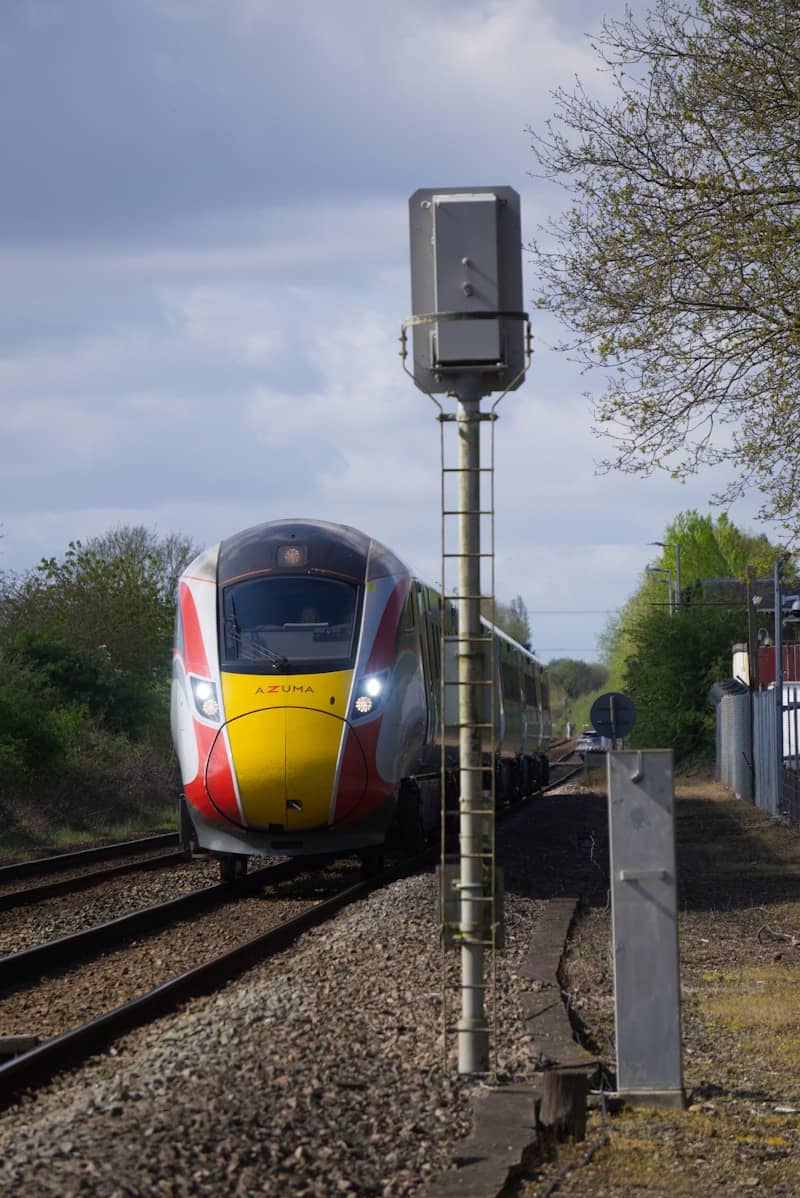 Modern train approaching a station on tracks.