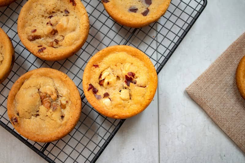 Round cookies with nuts and dried fruit on a black wire cooling rack