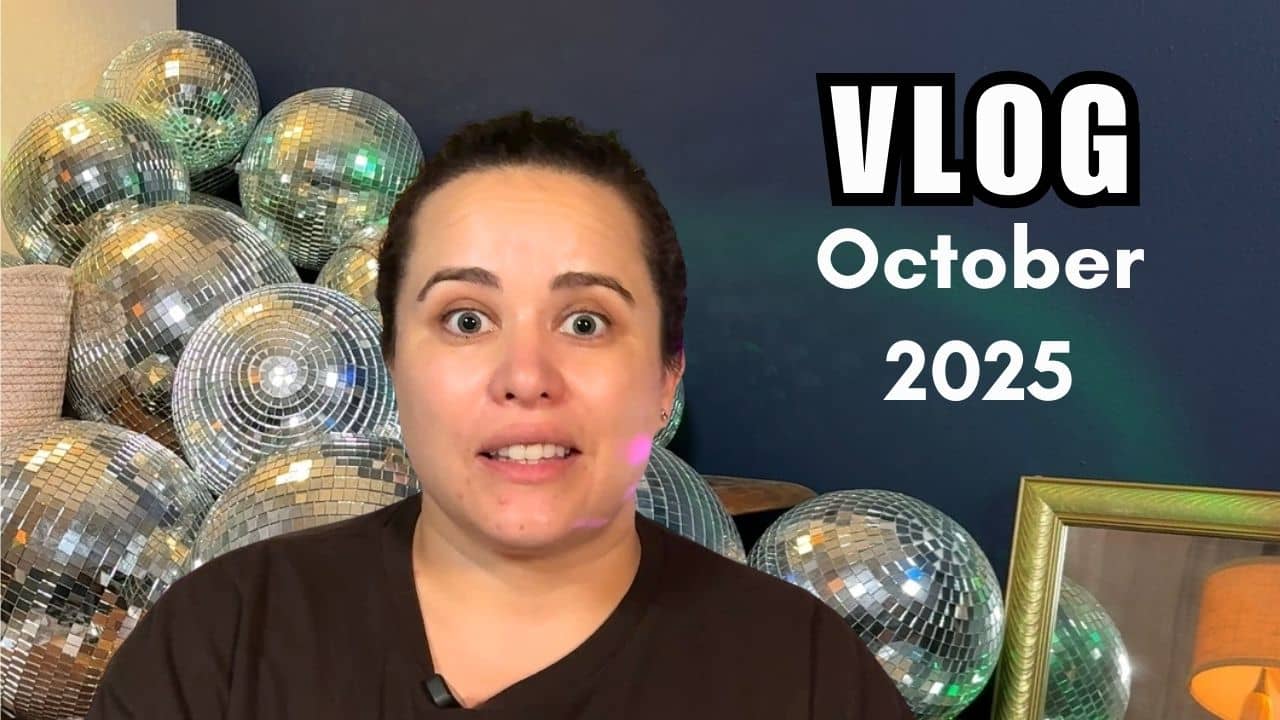 Woman with her eyes wide and mouth partially open in front of some disco balls.