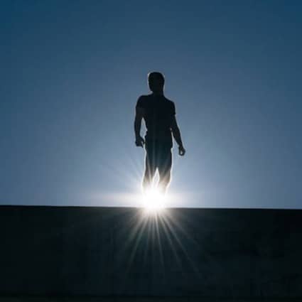 silhouette of man standing on bridge