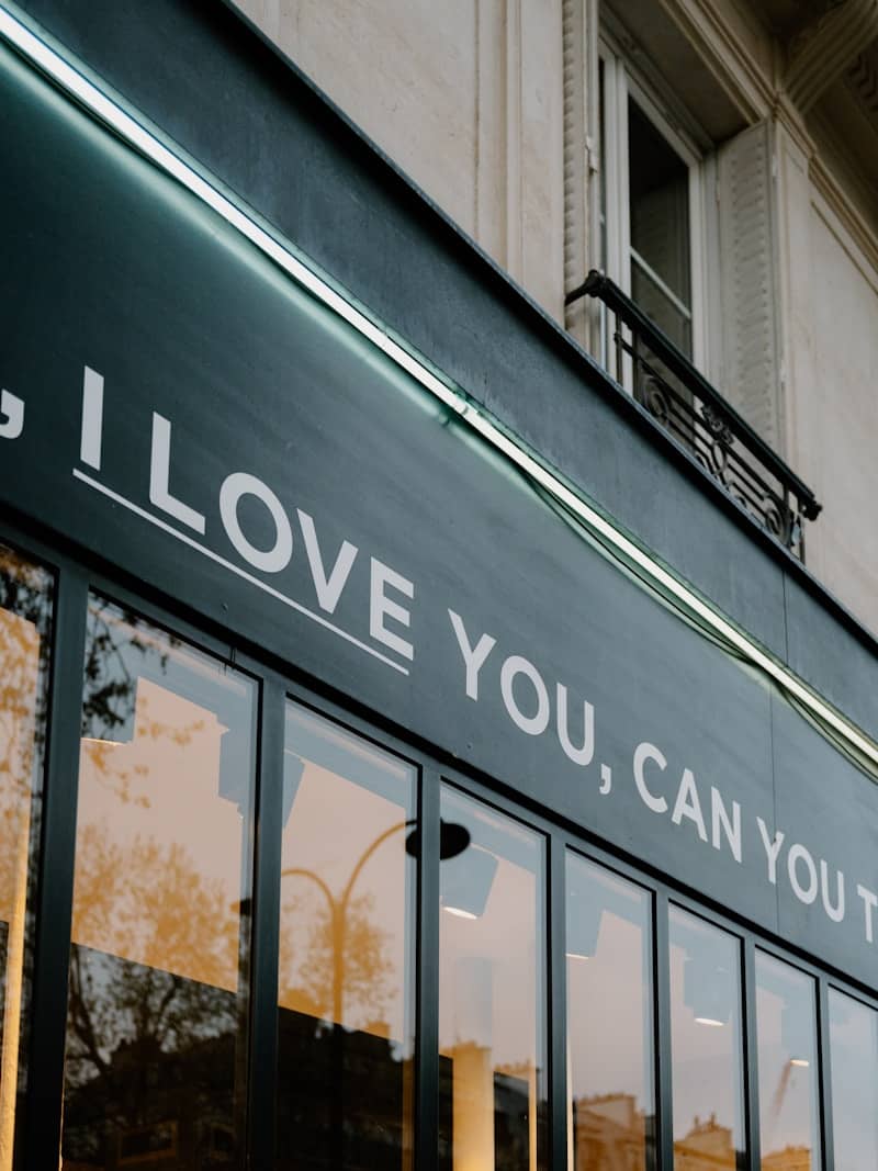 Storefront with "i love you, can you t" text.